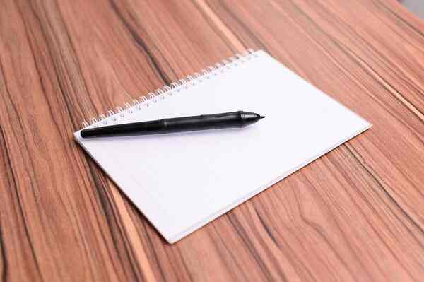 Бележник и писалка на маса със светлина